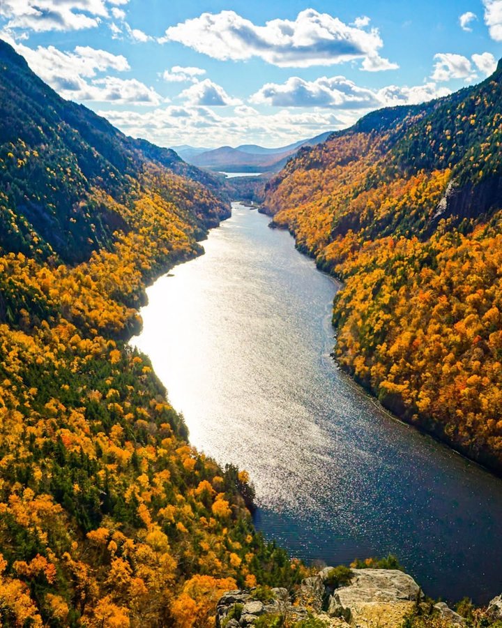 Instagram post by @lukekellytravels for Wilderness Culture. Caption reads: Fall colors surrounding Lower Ausable Lake in the....