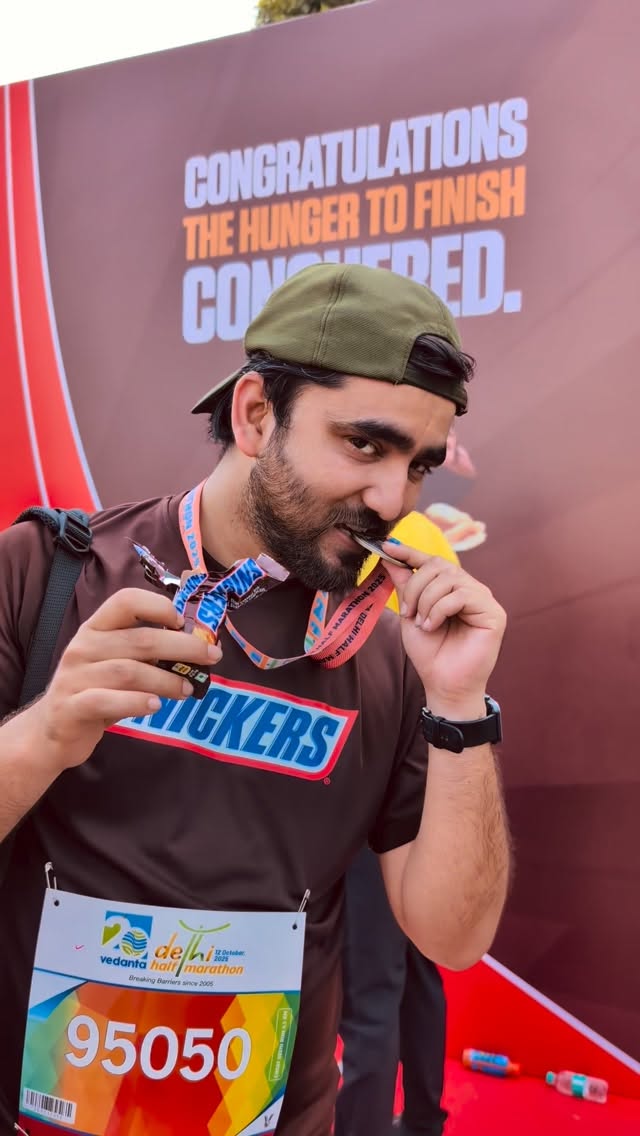 Instagram post by @delhihalfmarathon for Snickers. Caption reads: Grabbed a Snickers ✅ 
Finished #VDHM25 ✅
Grabbed a....