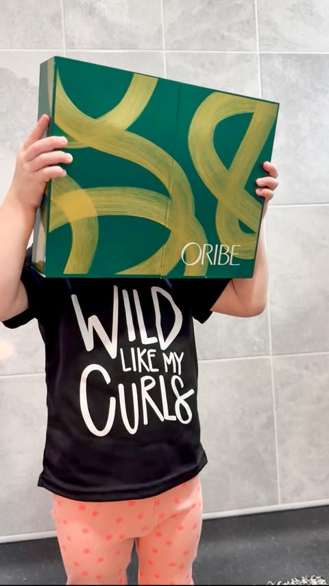 Instagram post by @life_as_mrsg for Oribe. Caption reads: I got a ‘little’ help unboxing the new Oribe....
