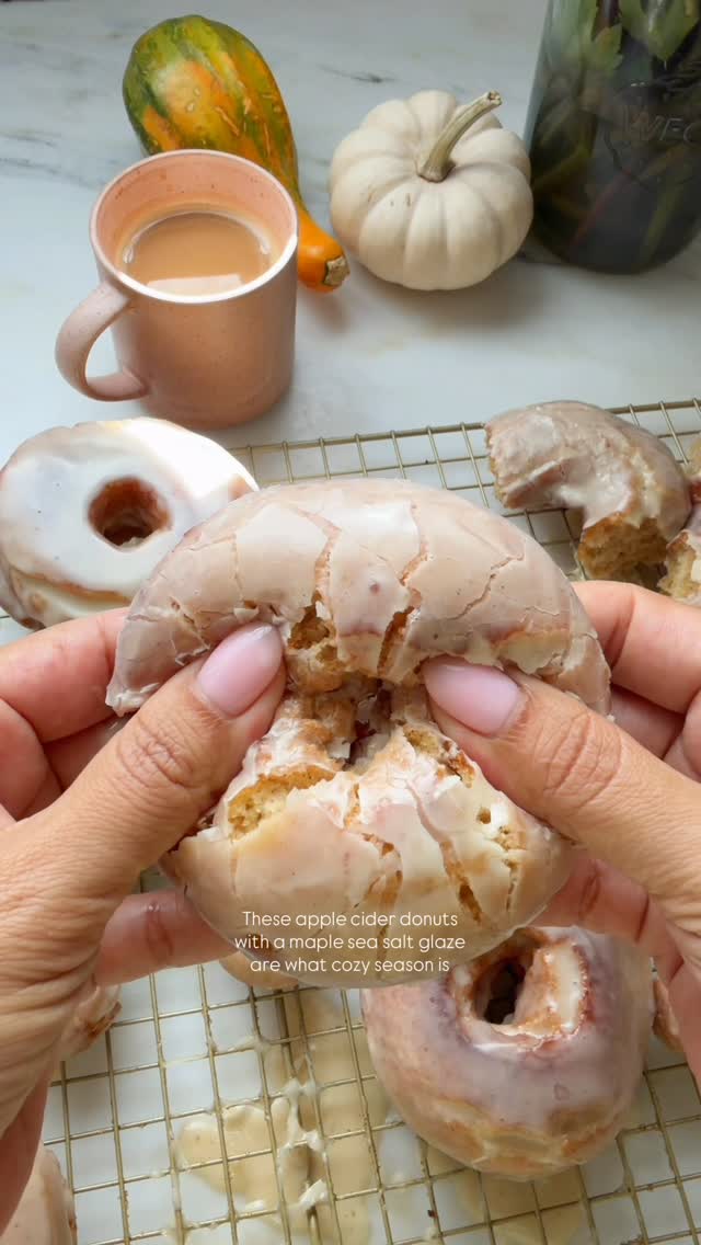 Instagram post by @acozykitchen for The Kitchn. Caption reads: apple cider donuts 🍎 🍩 dunked in a maple sea....