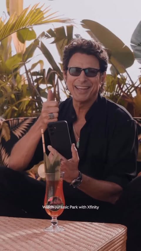 Instagram post by @jurassicyourworld for Xfinity. Caption reads: [...] Ian Malcolm. Aka @jeffgoldblum ✨🦖🍹 -....