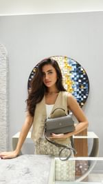 Instagram post by @deemaalasadi for Etienne Aigner AG. Caption reads: A visit to the newly opened @aignermunich boutique....