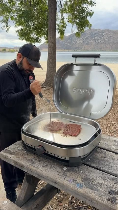 Instagram post by @cooking_with_fire___ for Solo Stove. Caption reads: [...] NY-style cheeseburger sandwiches 🔥....