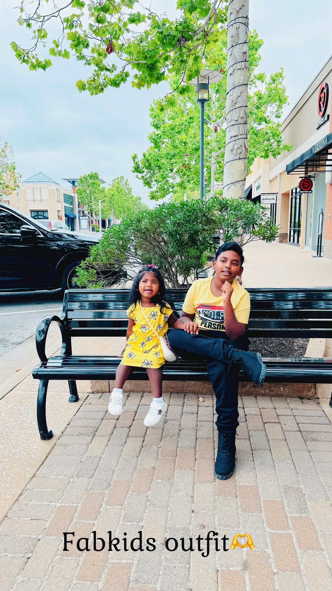 Instagram post by @fashionmejen for FabKids. Caption reads: My kiddos are twinning in yellow 🎒 Immanuel is....