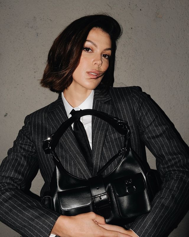 Instagram post by @irismittenaere for The Kooples. Caption reads: Always by my side 🖤 mon nouveau sac @thekooples x....