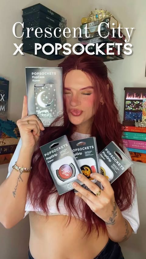Instagram post by @bookishlyaries for PopSockets. Caption reads: 🌙🦦 Sarah J. Maas X Popsockets 🦦🌙 omg guyyyssss....