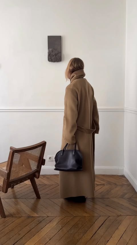 Instagram post by @mija_mija for The Row. Caption reads: Give me a big, cosy, oversized coat and I’m....