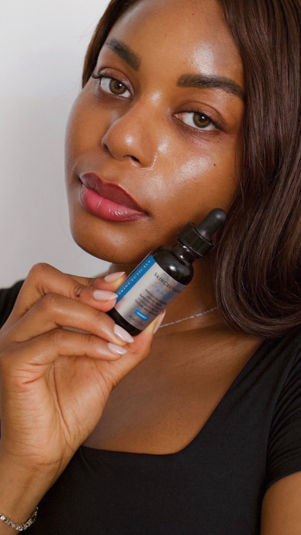 Instagram post by @kayebassey for SkinCeuticals. Caption reads: #MirrorSkin for vacation prep with the....