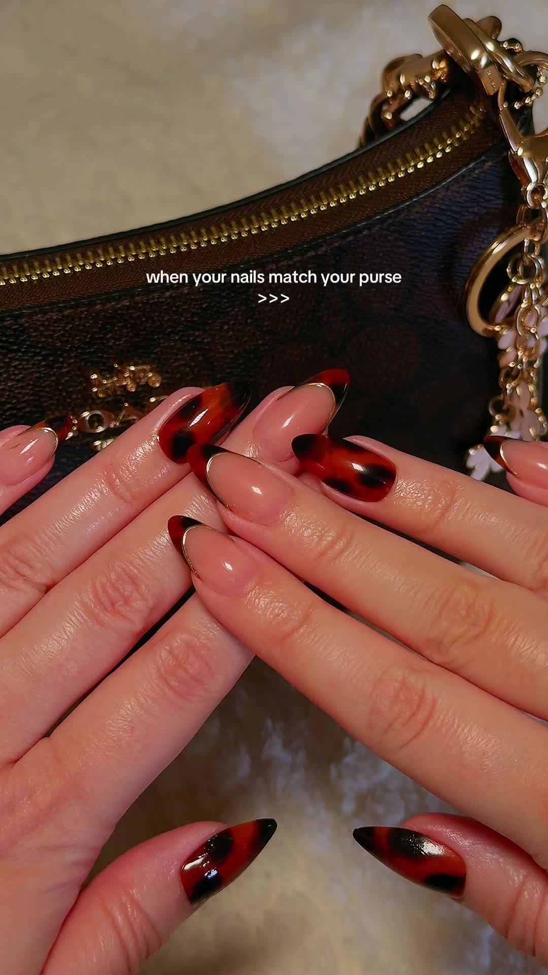 TikTok post by @naomikaylaa for VSALONNAIL. Caption reads: when your nails match your purse 🤎💋✨ >>> nails:....