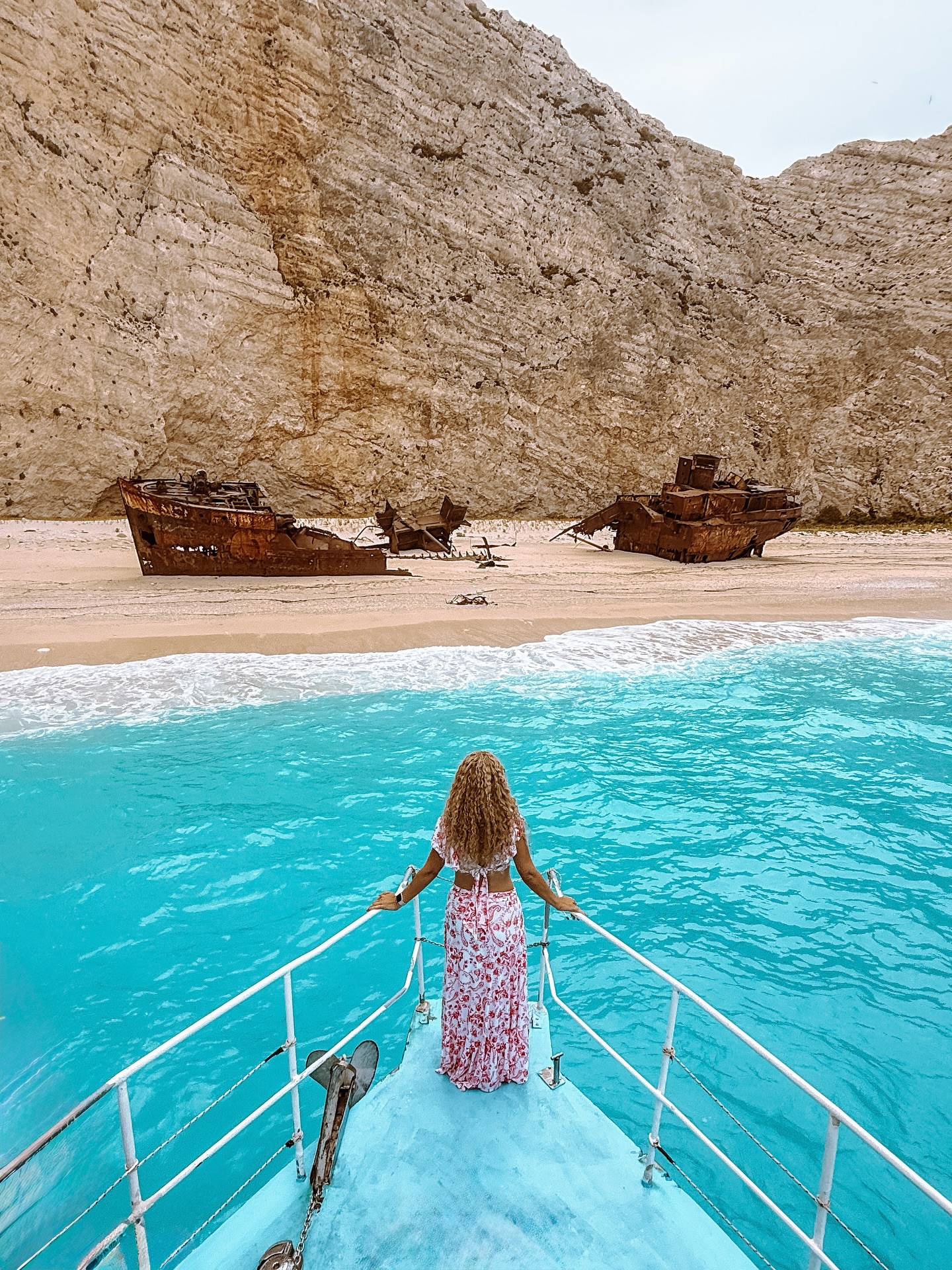 Instagram post by @greece_united for Girls LOVE Travel®. Caption reads: Standing at the bow, I take in the breathtaking....