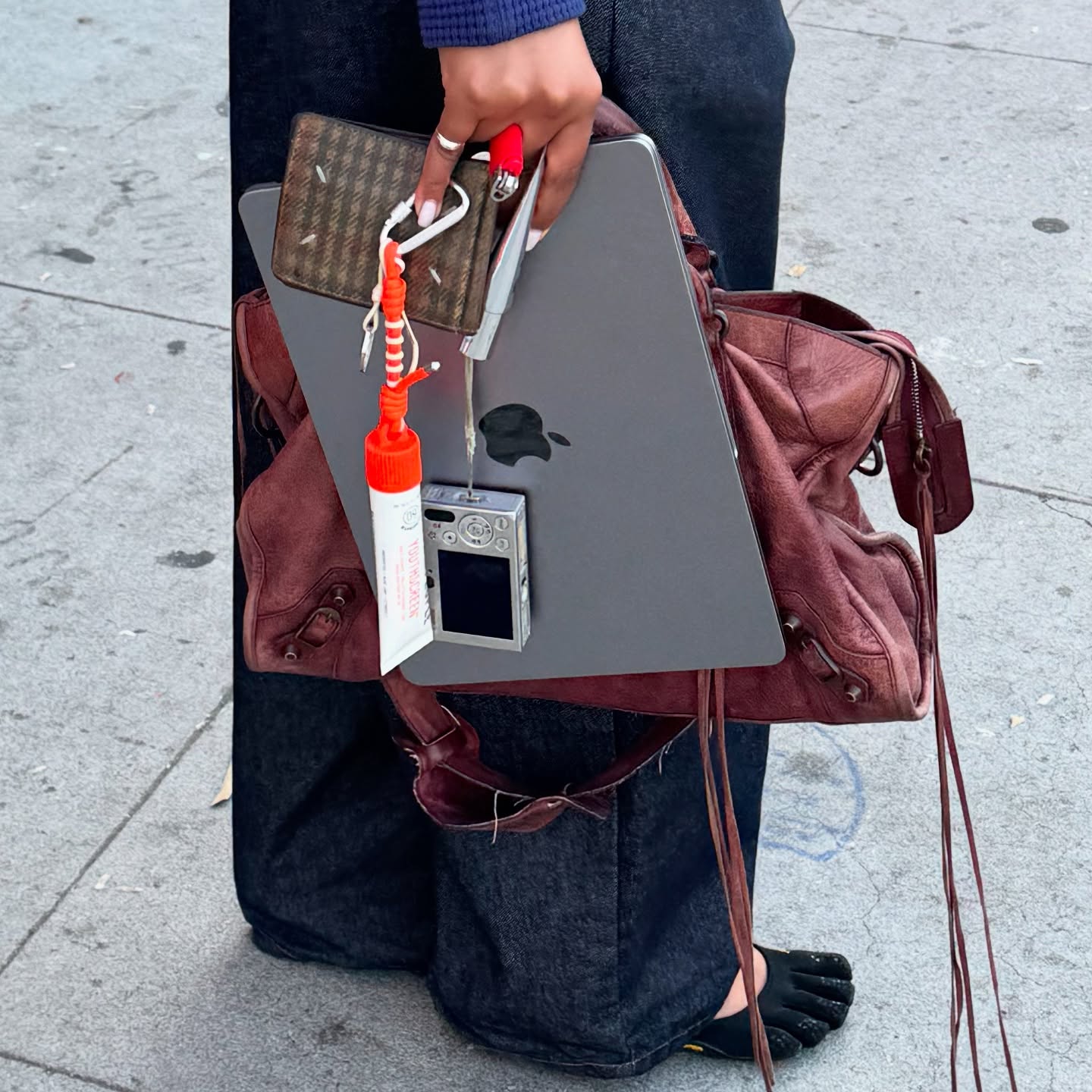 Instagram post by @girlscarryingshit for Youth To The People. Caption reads: lulu carrying shit: city bag, laptop, lipgloss,....