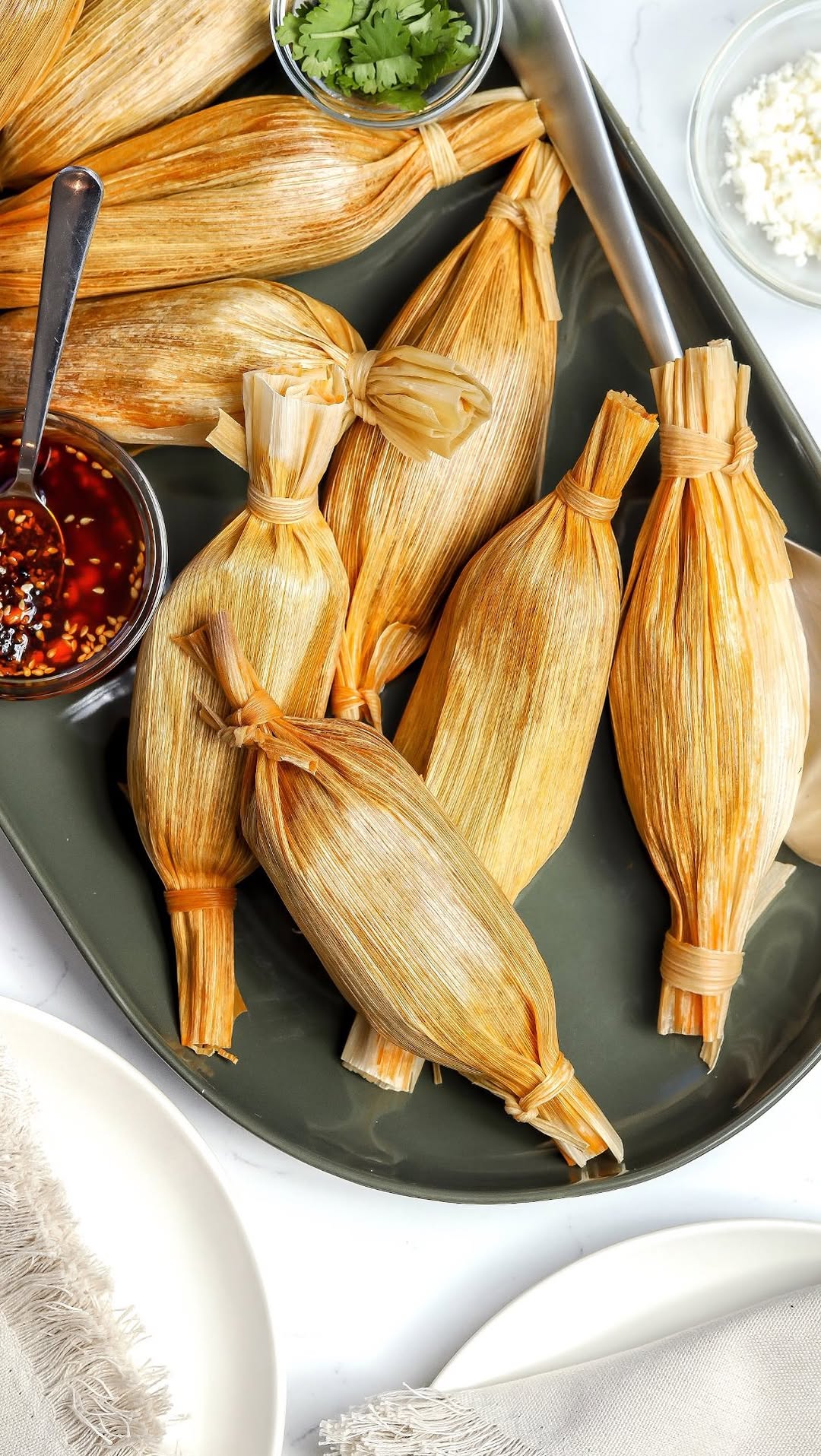 Instagram post by @foodmymuse for Crate and Barrel. Caption reads: These Red Chile Beef Tamales are by far my....