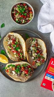 Instagram post by @eat_figs_not_pigs for LightLife. Caption reads: These Mediterranean Style Tacos are a fun twist on....