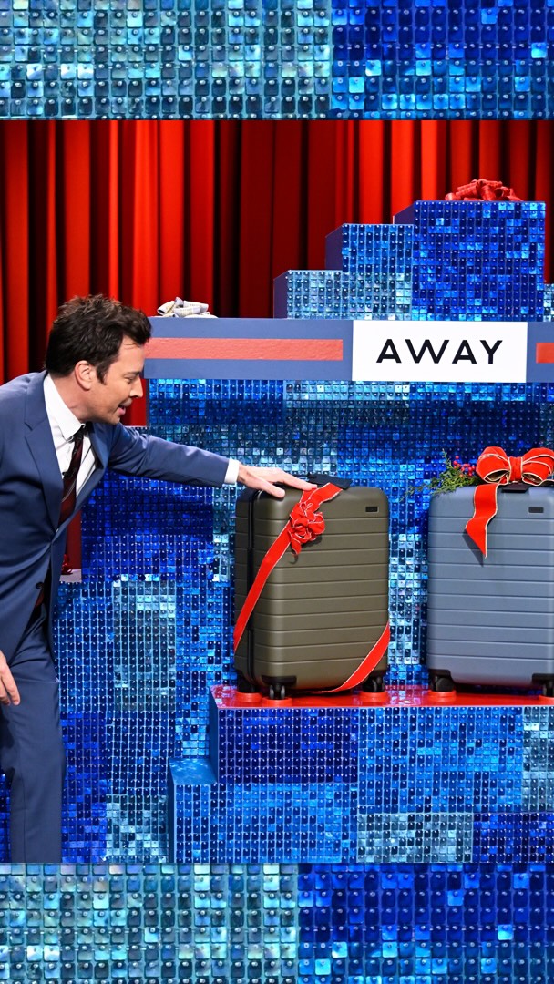 Instagram post by @fallontonightbts for Away. Caption reads: Jimmy gives the Studio 6B audience an @away Bigger....
