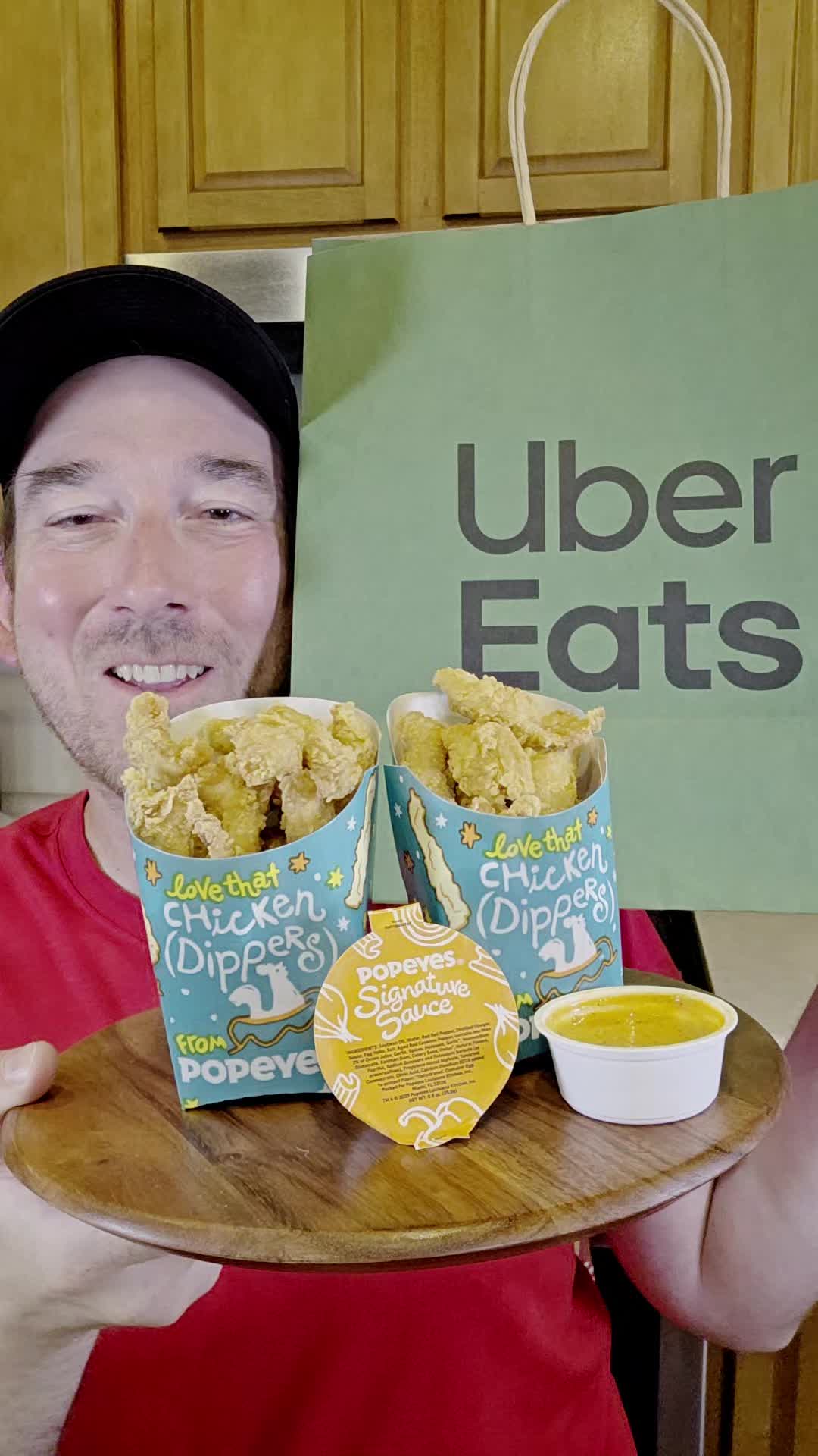 TikTok post by @snackolator for Uber Eats. Caption reads: #UberEatsPartner Popeyes just dropped new Chicken....