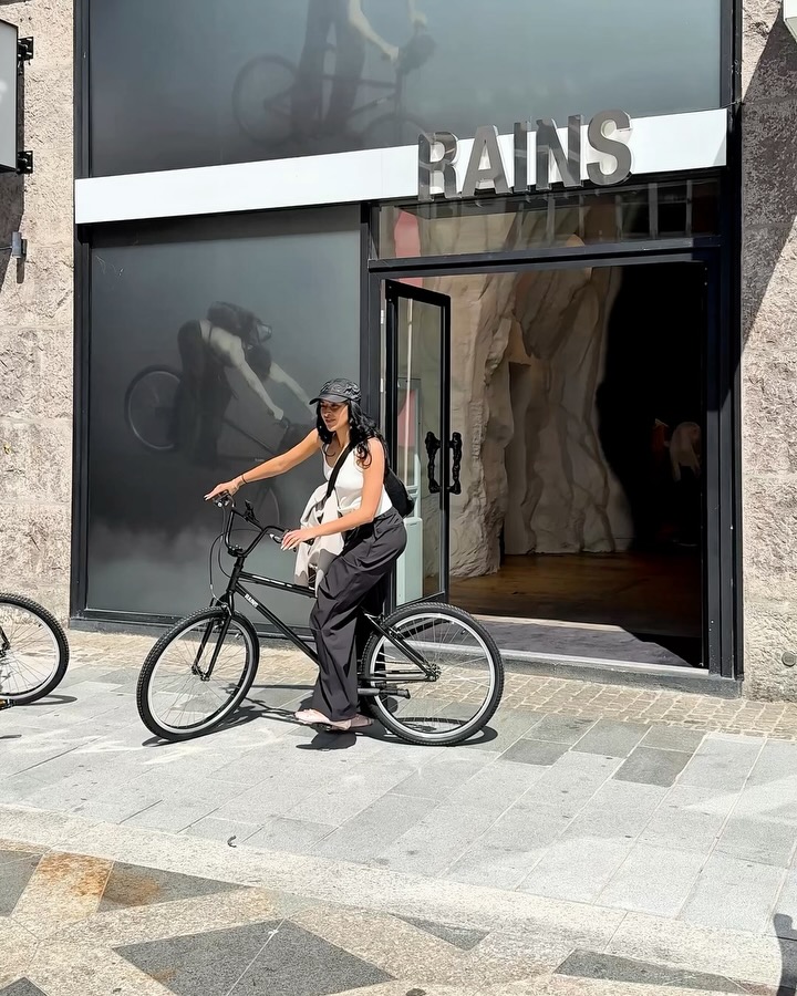 Instagram post by @copenhagenfrow for Rains. Caption reads: ad| a summer day in CPH w/ @rains bike.