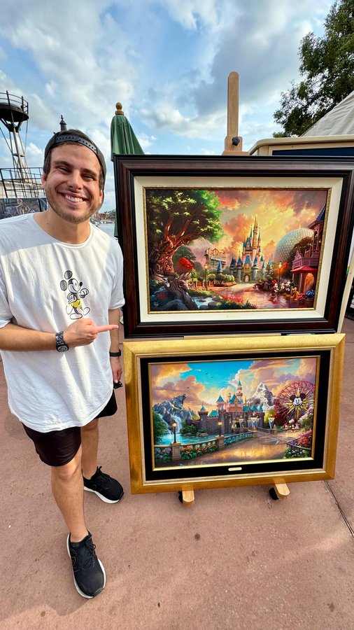 Instagram post by @thethemeparkdad for Thomas Kinkade Studios. Caption reads: The way these two paintings capture the magic of....