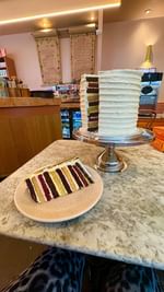 Instagram post by @foodies.explores for Cutter & Squidge. Caption reads: 20 LAYER BIRTHDAY CAKE in London 🎂 ➡️ Follow....