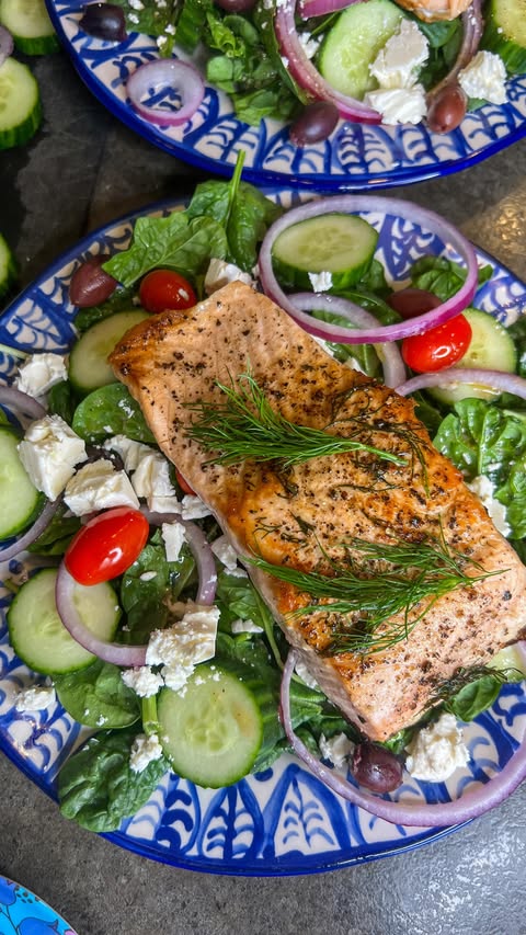 Instagram post by @bellylaughliving for Bluehouse Salmon. Caption reads: Greek Salmon Spinach Salad using Bluehouse Salmon.....
