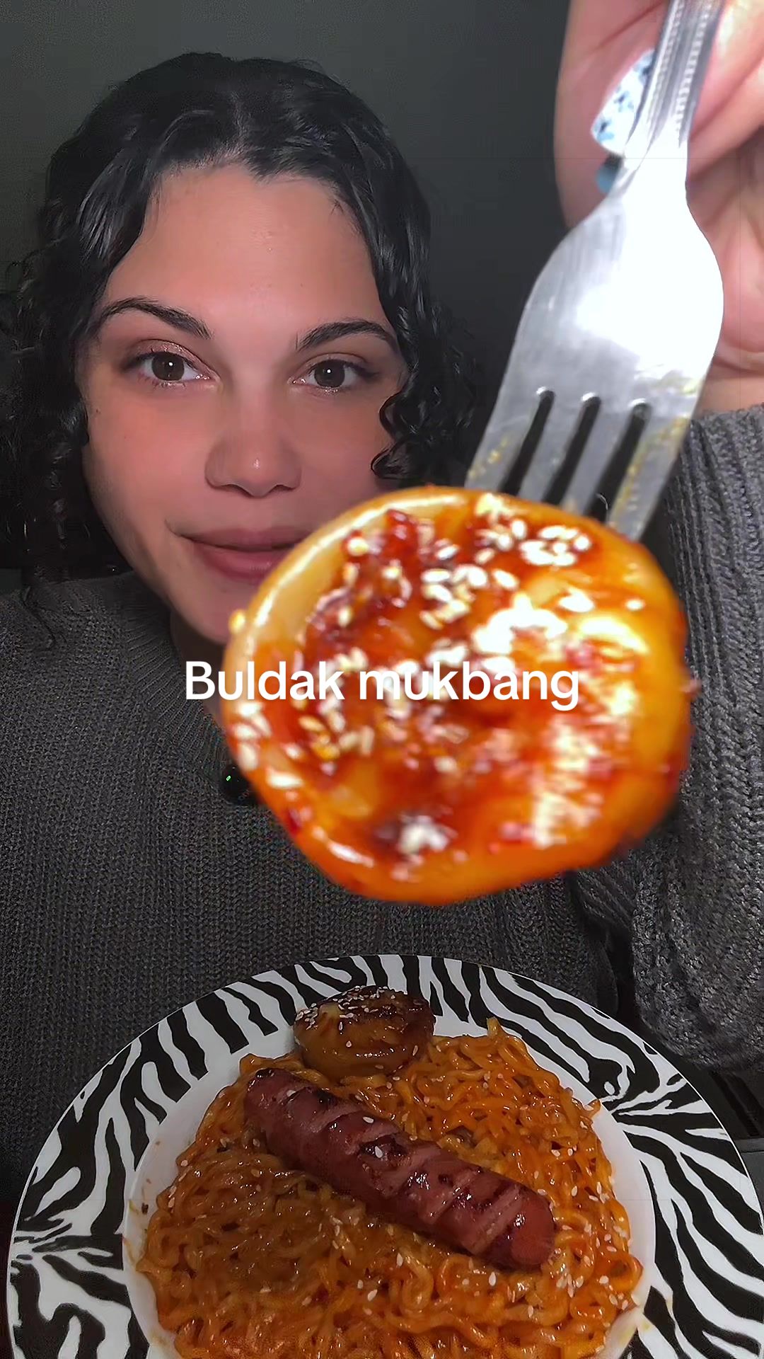 TikTok post by @carly.eats for bibigo USA. Caption reads: [...] #eatwithme @buldak global @bibigo USA.
