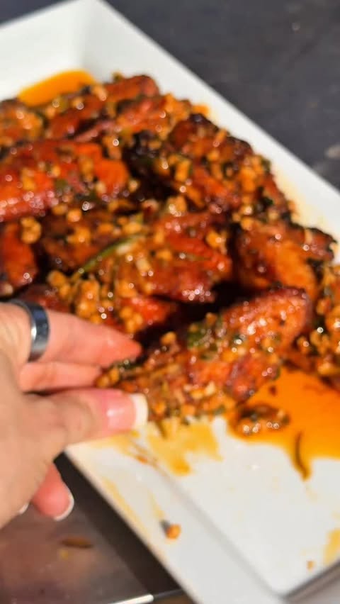 Instagram post by @girlgonegrilling for Bear Mountain BBQ. Caption reads: Smoky, crispy wings tossed in Cajun cowboy butter....