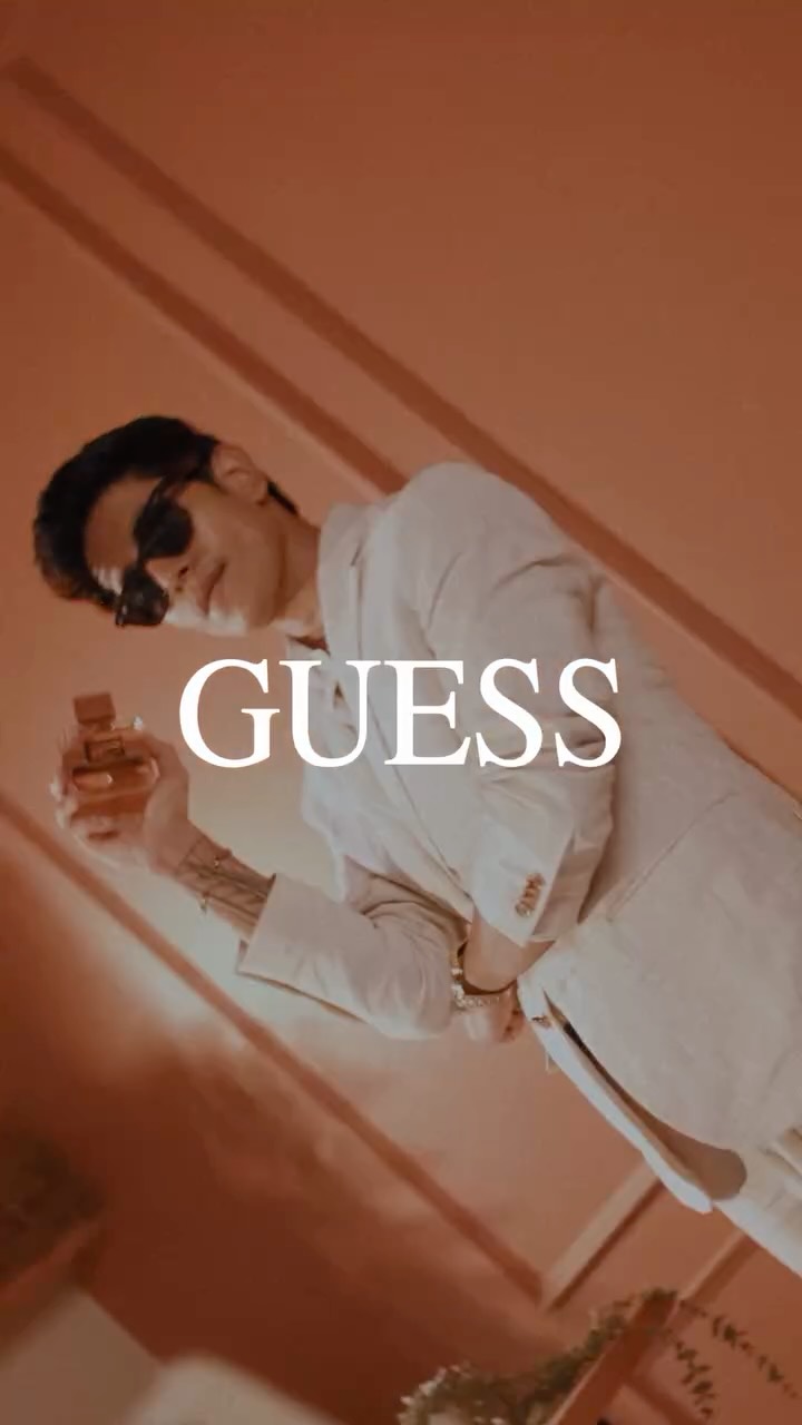 Instagram post by @theabhishekrathod for GUESS. Caption reads: An unmistakable signature built on contrast—fiery....