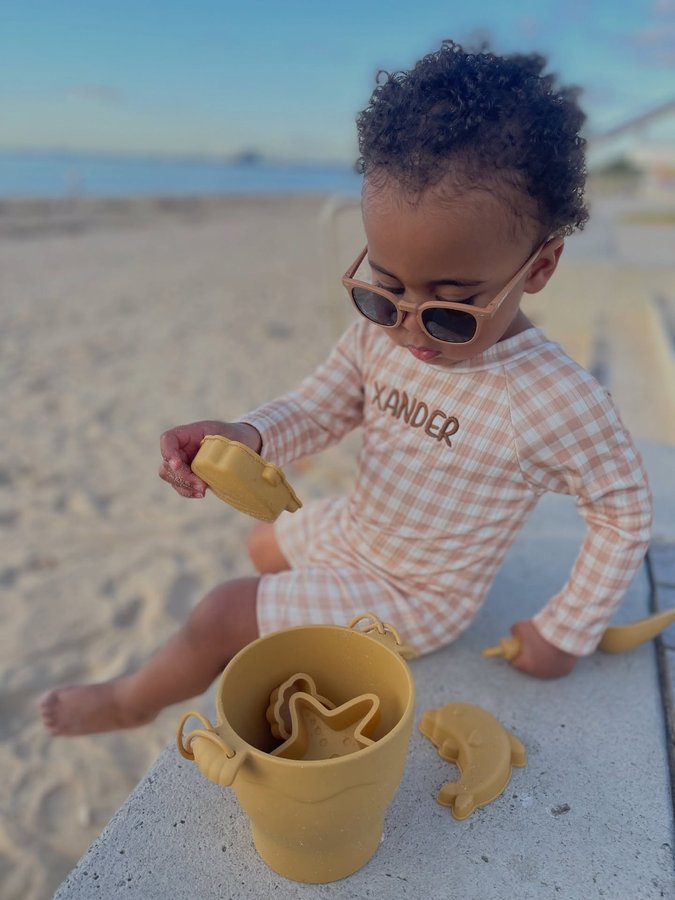 Instagram post by @metier.social for Polarised Baby Sunglasses. Caption reads: little explorer Xander is soaking up the sun in....