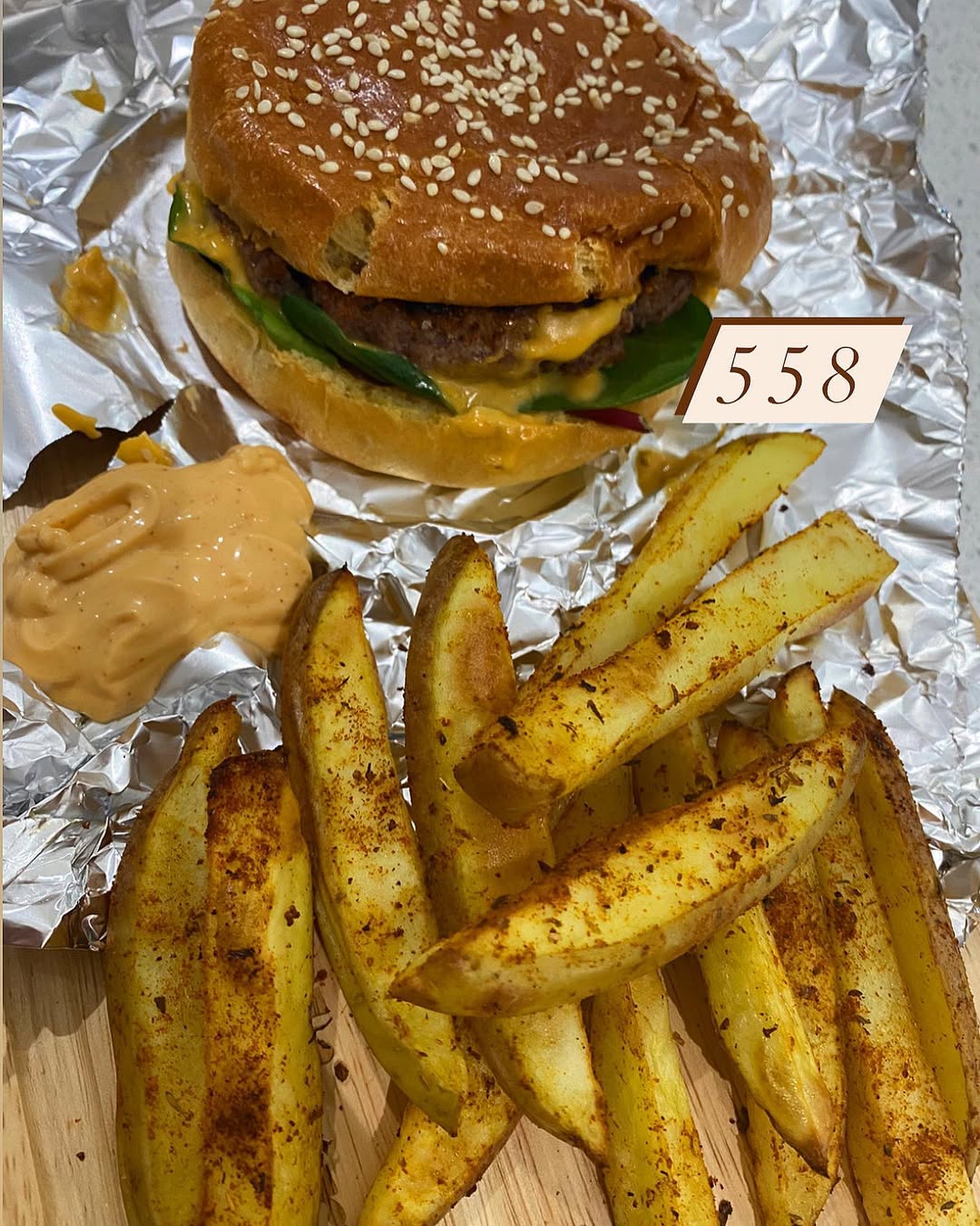 Instagram post by @fitfooddiary_x for Spicentice. Caption reads: Cheese burger & homemade chips 😋
🤎 chop and par....