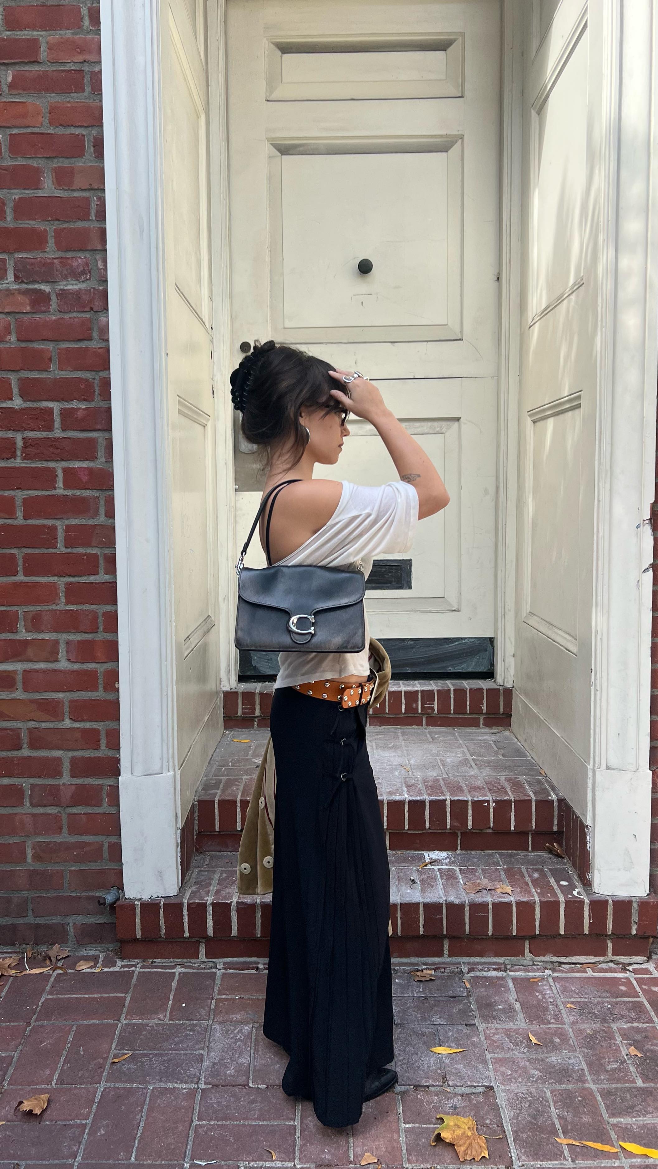 Instagram post by @emmyqandrews for Coach. Caption reads: My Coach Tabby comes everywhere with me this Fall....