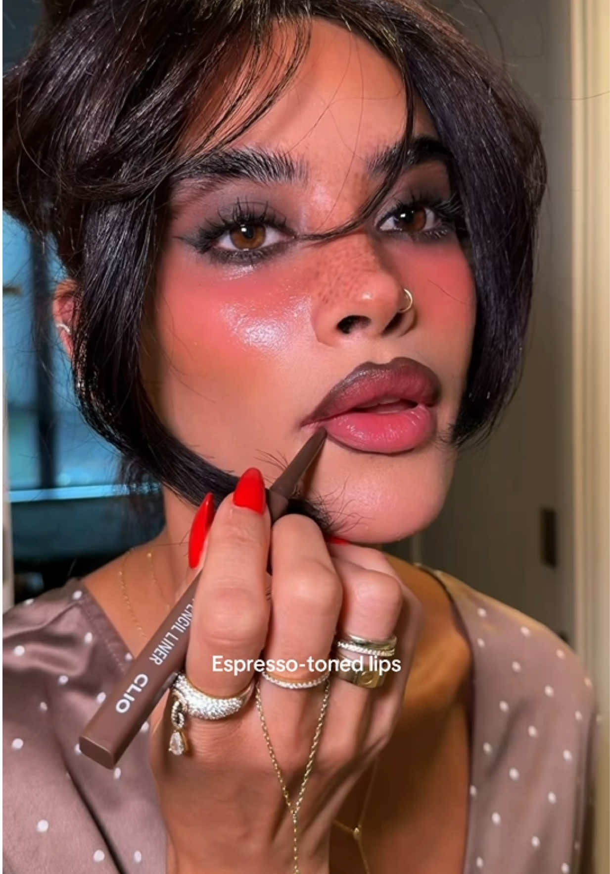 TikTok post by @huda_gash for CLIO US. Caption reads: Dark, whimsical Halloween glam 🖤 Shop CLIO during....