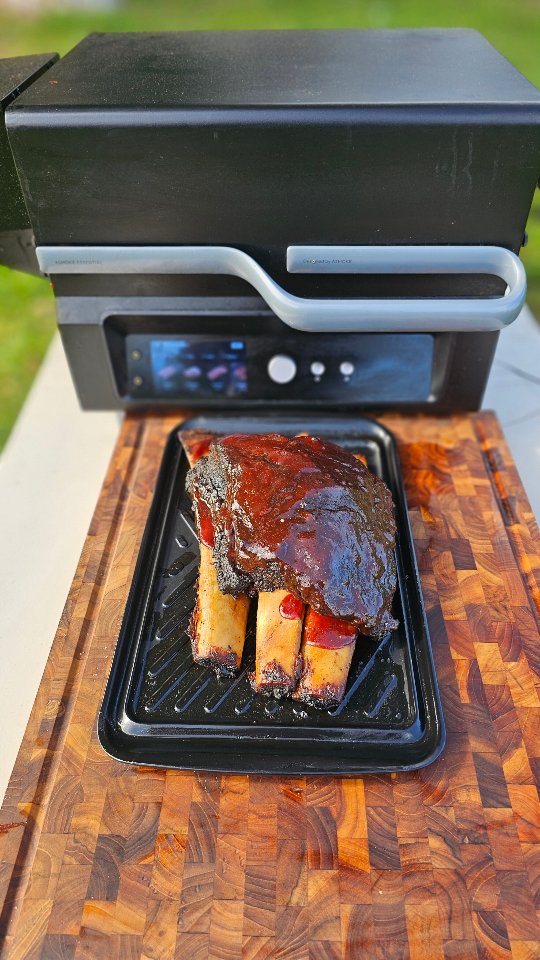 Instagram post by @chef.kennyeats for Asmoke Grill. Caption reads: Smoked Dino Ribs with Peach Ají Panca BBQ Sauce....