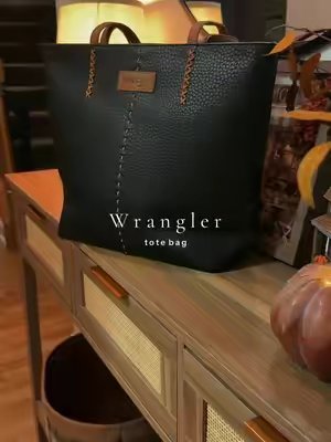 TikTok post by @katiegraff2 for Vaqueras Outfitters. Caption reads: So pretty 🍂 @Vaqueras Outfitters #purse #totebag....