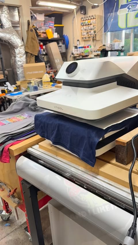 Instagram post by @6_8woodworks for xTool. Caption reads: The @xtool.official Apparel Printer and....