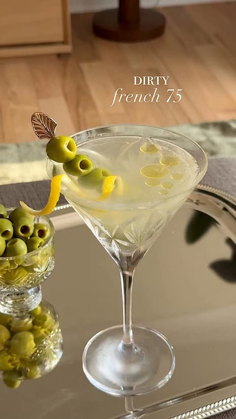 Instagram post by @yellowbellykelly for Whole Foods Market. Caption reads: French 75 🤝 Dirty Martini 🍋🫒🍸

Because why....