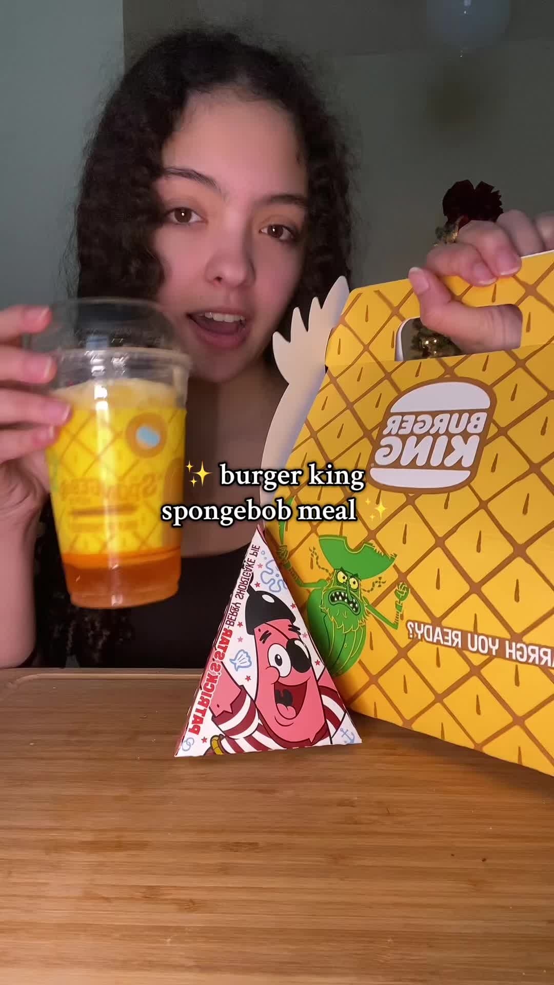 TikTok post by @curlygirlgrubs for Burger King. Caption reads: unbox the new burger king spongebob meal with me....