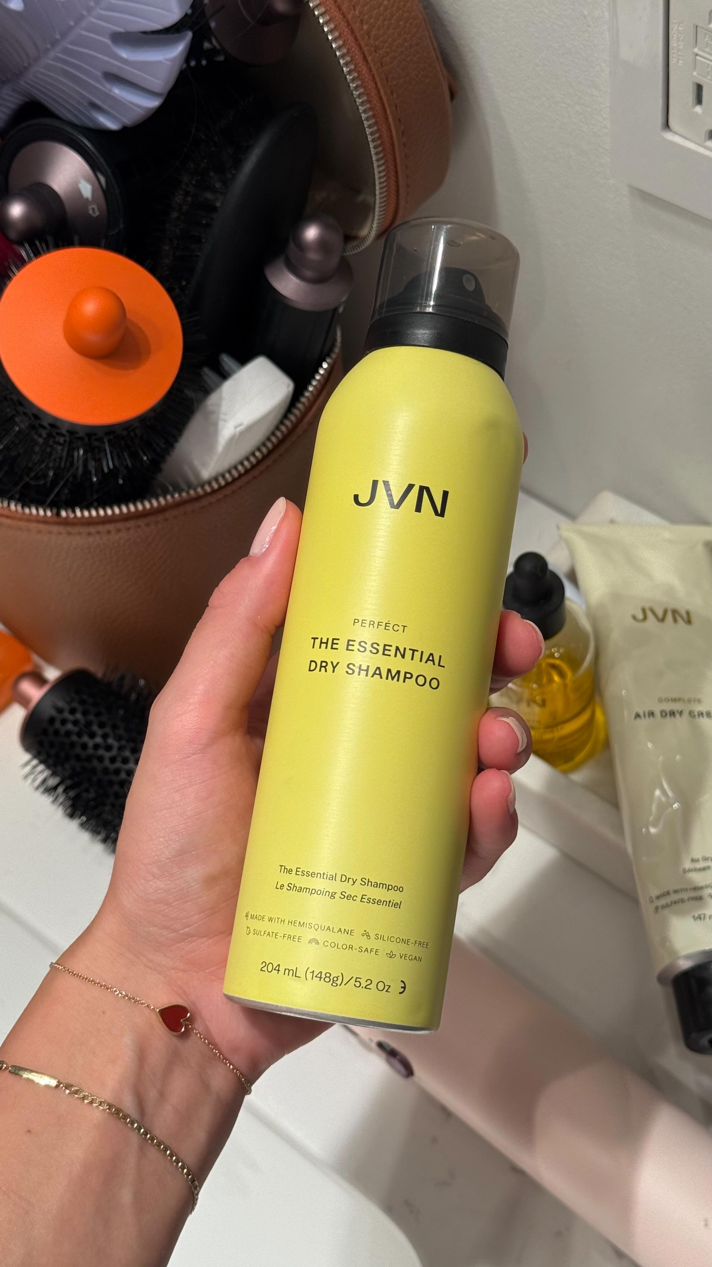 Instagram post by @zhanna.red for JVN Hair. Caption reads: What’s in my bag every single day this summer 💛....