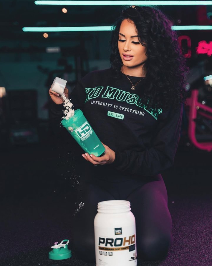 Instagram post by @jenniferdorie_ifbbpro for HD MUSCLE. Caption reads: Are you team vanilla or team chocolate protein....