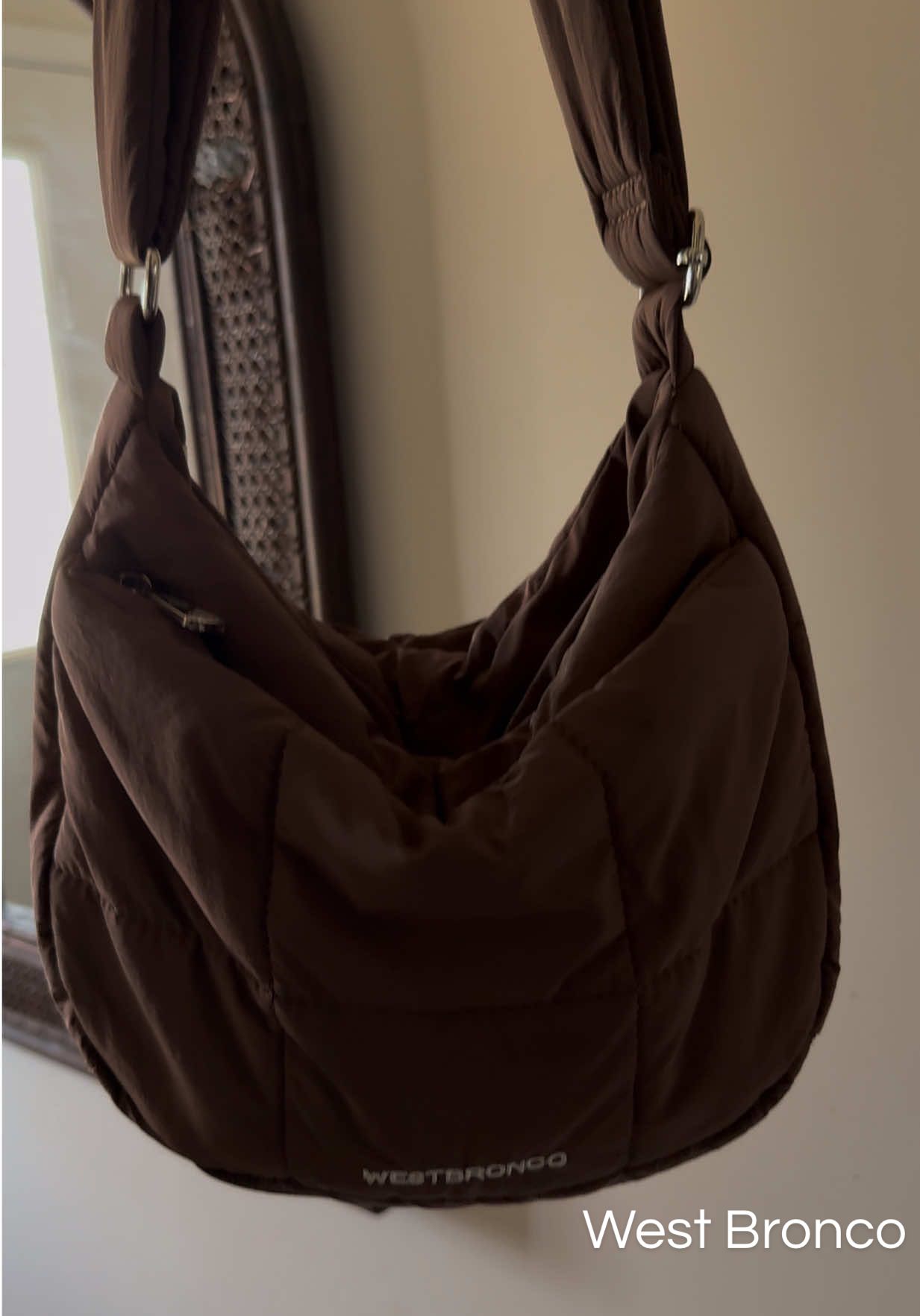 TikTok post by an influencer for WESTBRONCO. Caption reads: [...] perfect puffer purse ↑ ↑ ↑ @WESTBRONCO.