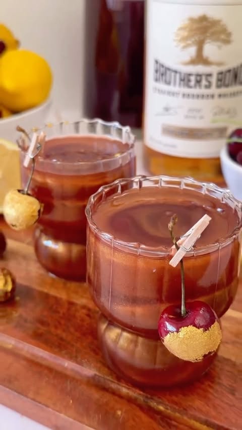 Instagram post by @brittsbevs for Brother's Bond Bourbon. Caption reads: When the clock strikes midnight, drop the cherry....