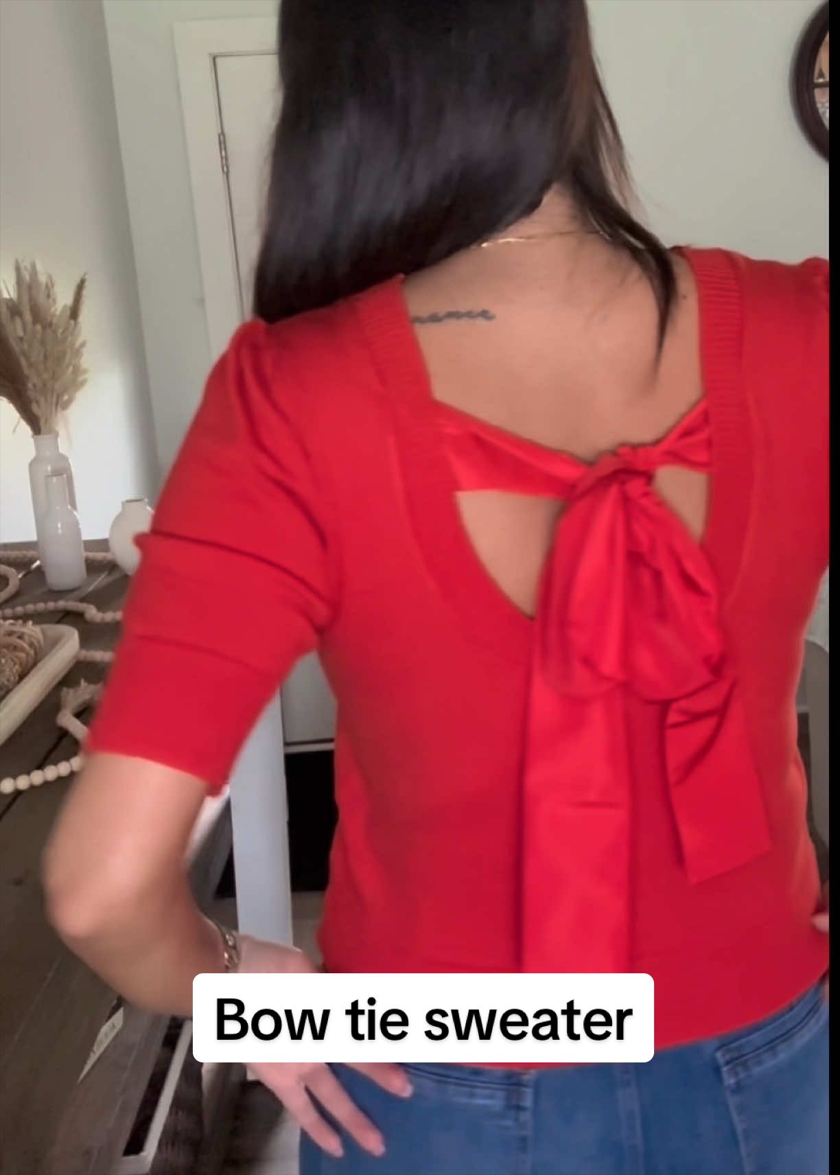 TikTok post by @katabild for OmmigO. Caption reads: The bow tie on the back of this sweater is....