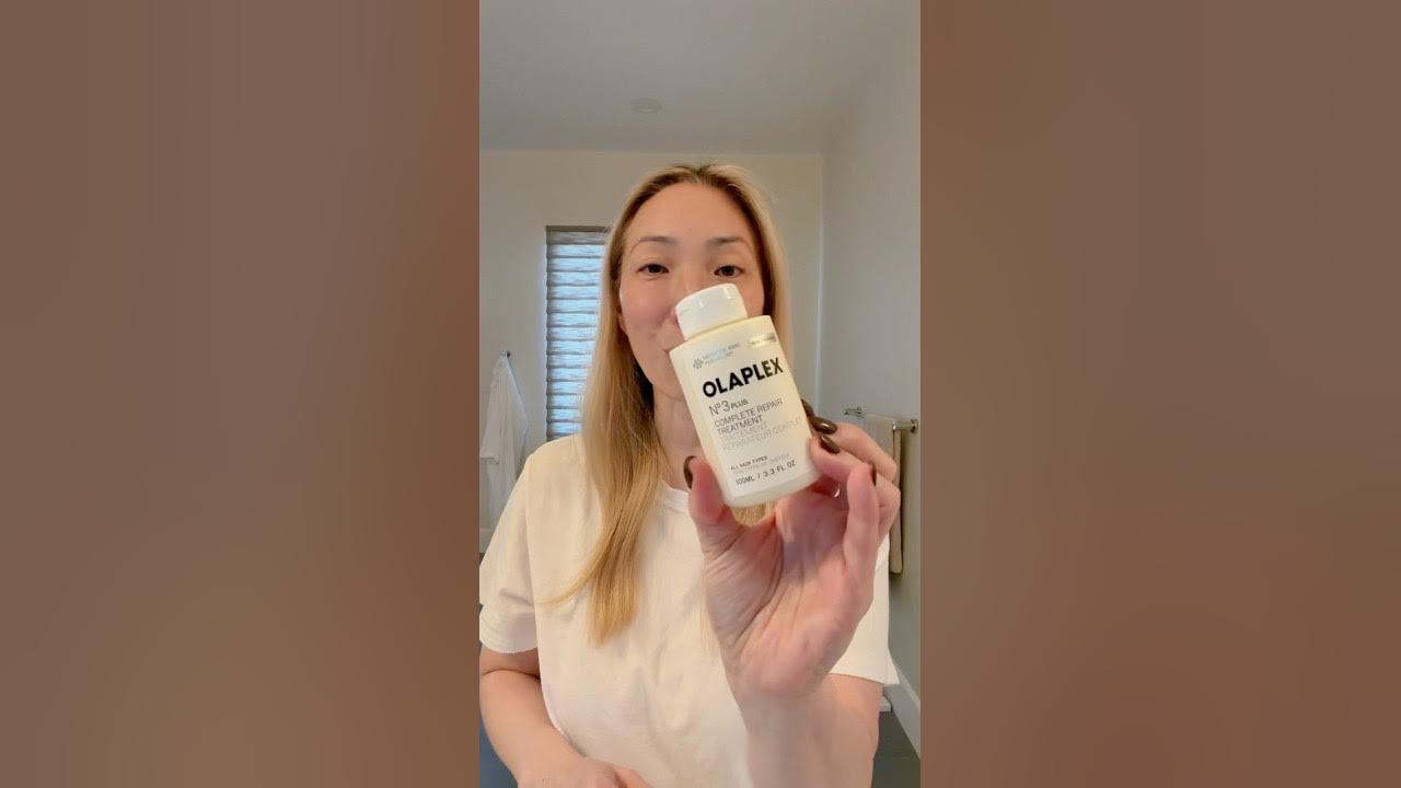 YouTube post by @TheMicheleWang for OLAPLEX. Caption reads: [...] foundation of my hair routine. The NEW....
