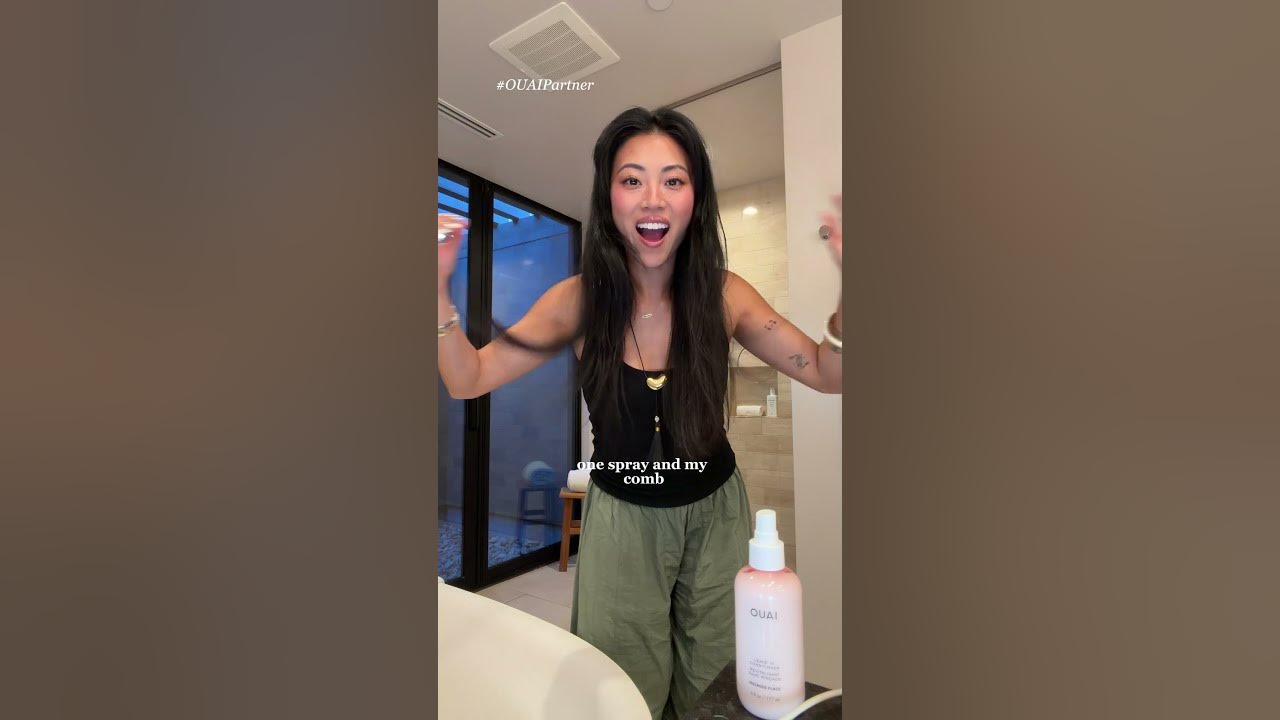 YouTube post by @christineleeee for OUAI. Caption reads: [...] frizz, detangles and heat protection)....
