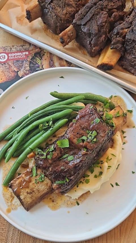 Instagram post by @jennys_coastal_cuisine for GoodLife Proteins. Caption reads: Slow roasted red wine beef short ribs over creamy....