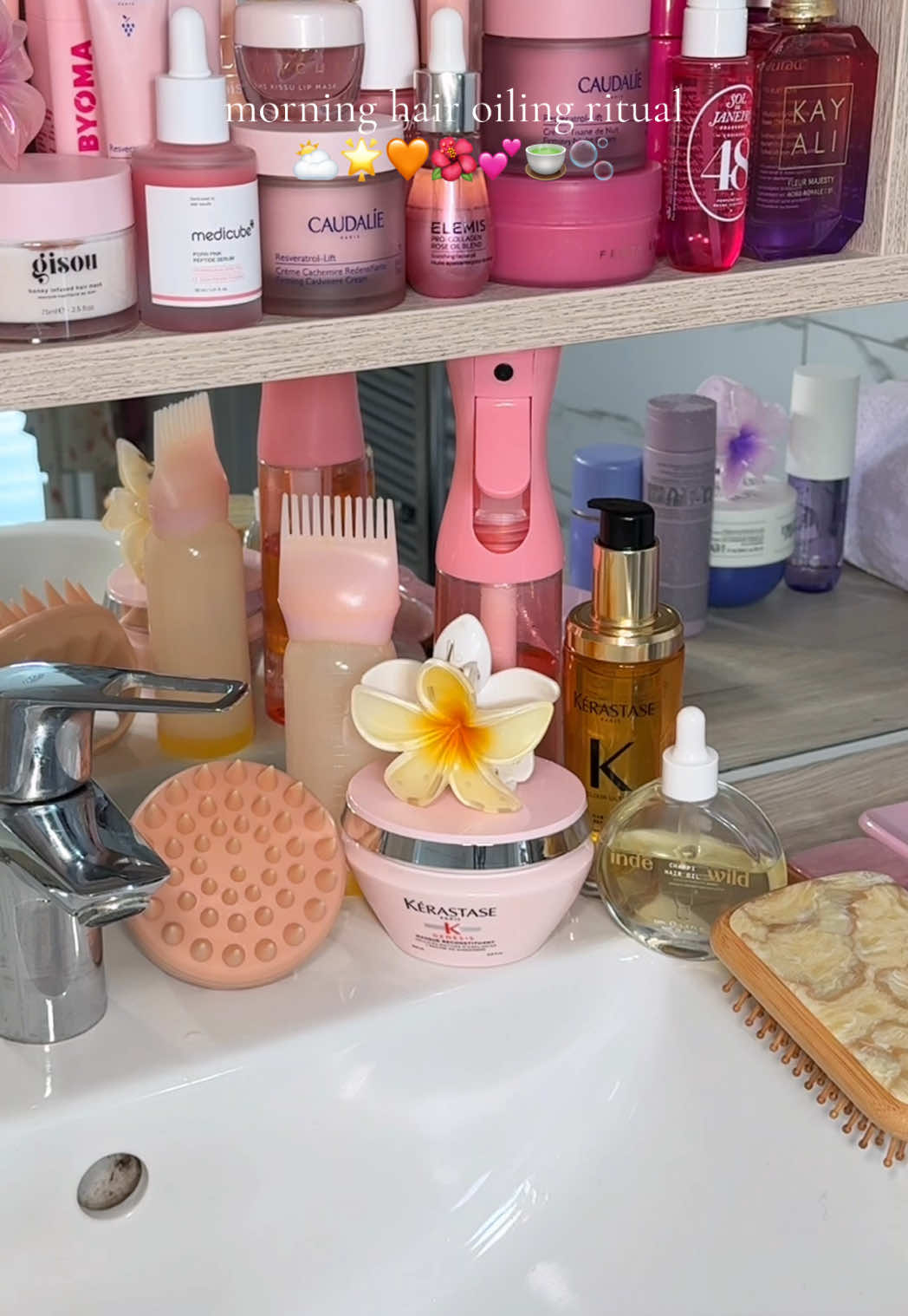 TikTok post by @by.emmaleah for Emi Jay. Caption reads: [...] oiling ritual ⛅️🌟🧡🌺💕🍵🫧 products @Emi....