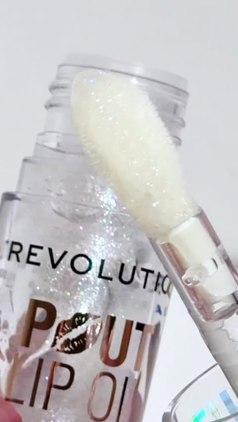 Instagram post by @marriumsshah for Makeup Revolution. Caption reads: Tried the Revolution Pout Lip Oil in Holographic....